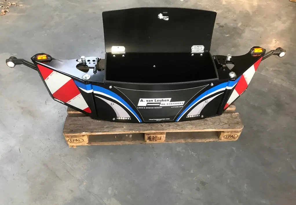 Box CAT 1 front weight bumper with open storage compartment, warning markers and lights, placed on a pallet