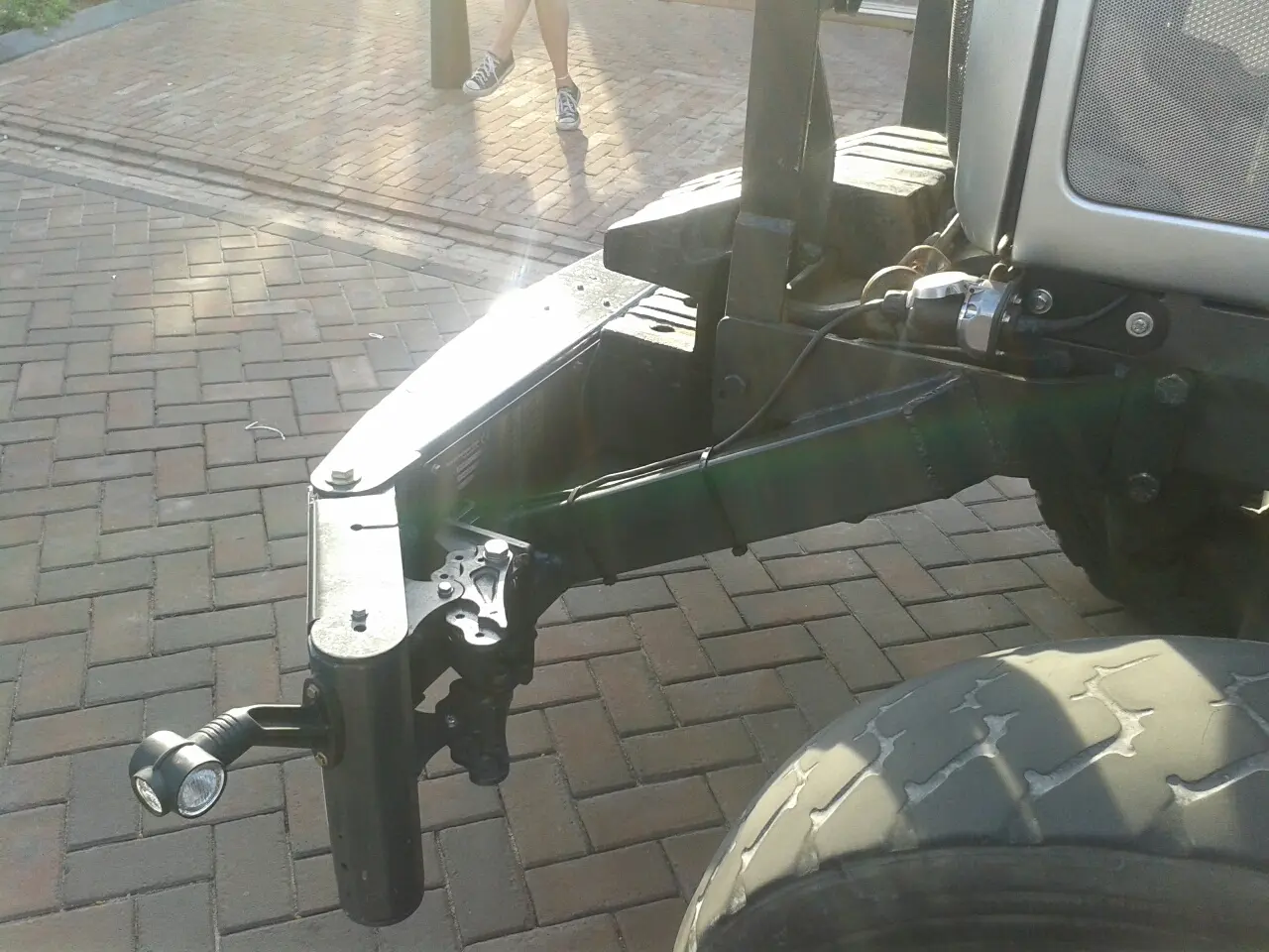 Box 50L without front linkage mounted on the front of a tractor, shown on a paved surface in sunlight