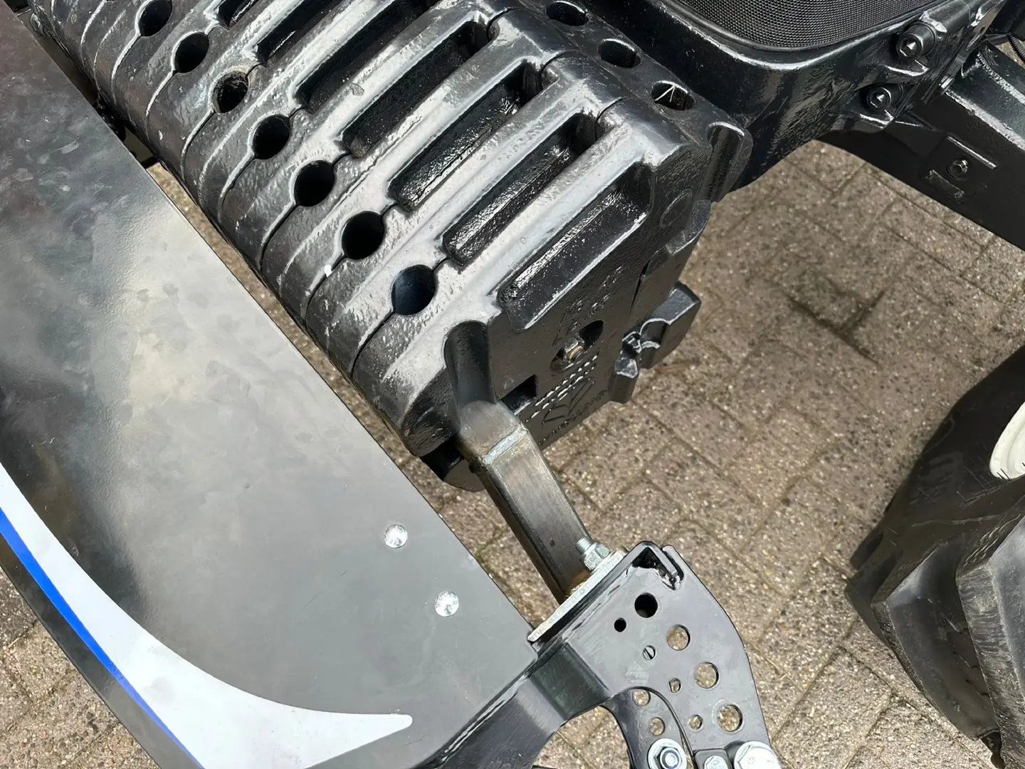 Close-up view of a Box 50L without front linkage bumper mounted on a tractor with visible weights and attachment bolts