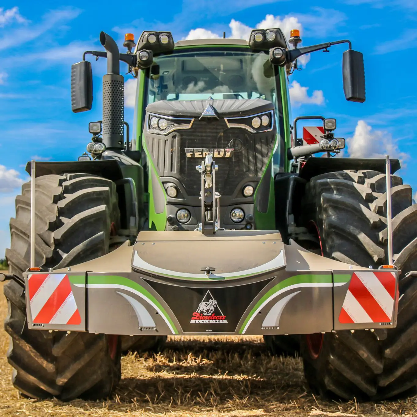 Grand tracteur avec doubles roues avant et arrière, équipé d'un pare-chocs avant pondéré avec bandes réfléchissantes