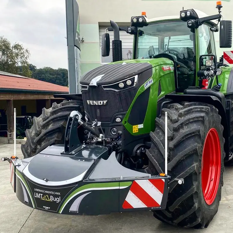Tracteur vert à grands pneus équipé d’un pare-poids avant avec bandes réfléchissantes rouges et blanches