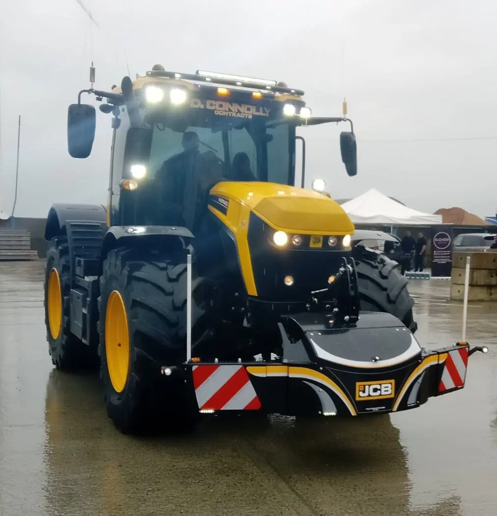 A yellow and black tractor fitted with a front weight bumper with LED lights and red-and-white safety markings