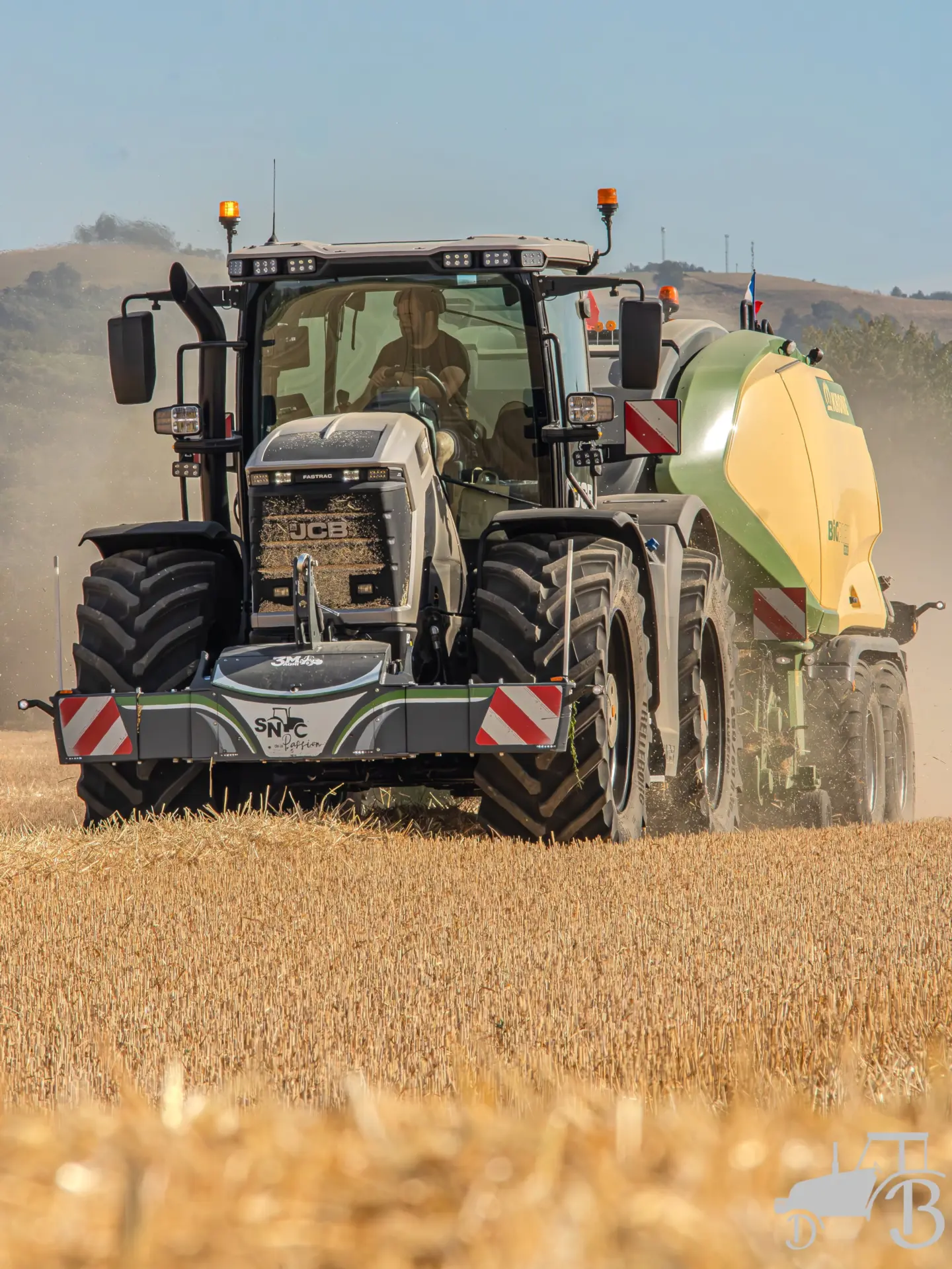 Tractor with a front weight bumper and LED lights working in a harvested field on a sunny day