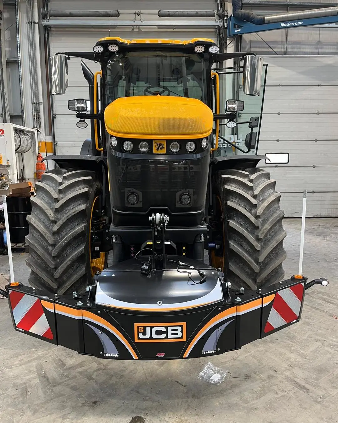 A yellow and black tractor with a mounted front weight bumper featuring LED lights and red and white reflectors