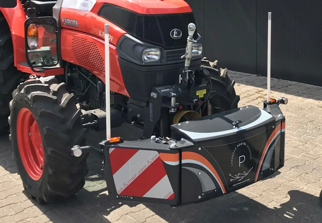 Front view of a red tractor fitted with a large black and orange front weight bumper with reflective stripes