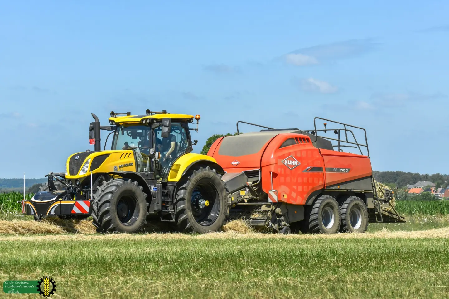 Yellow tractor with a front weight bumper attached, pulling a large red baler on a grassy field