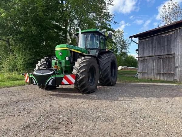 John Deere tractor with a TractorBumper front bumper and rear weight