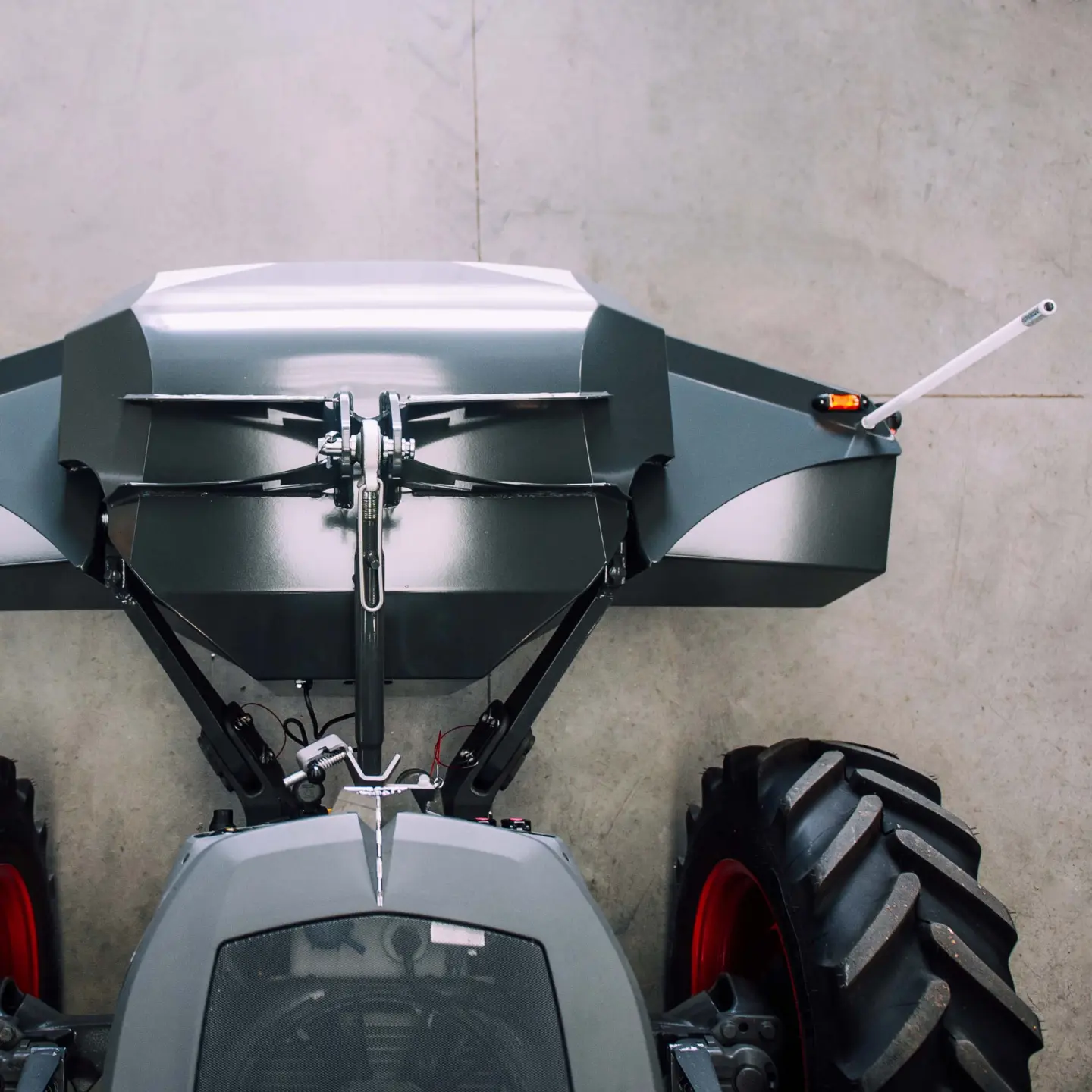Front view of a tractor showing a mounted front weight bumper with a warning rod and visible attachment points
